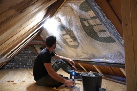 Uitvoerder de vries tijdens dakisolatie op een hete zolder