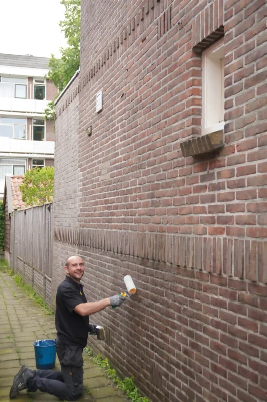 Medewerker de Vries Isolatie tijdens het impregneren van een muur
