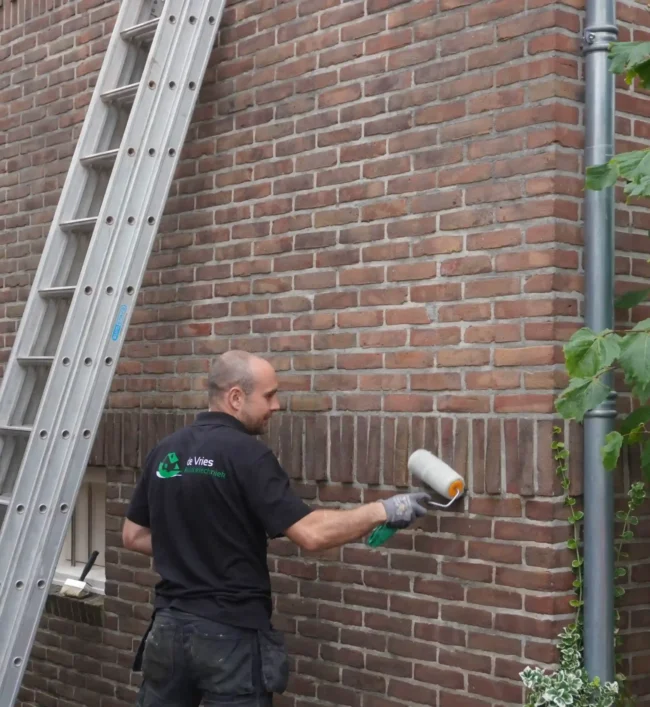 Medewerker de Vries Isolatie tijdens het impregneren van een muur