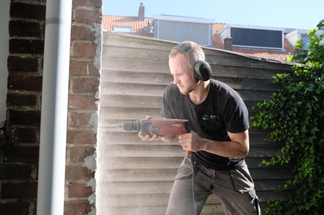 Medewerker de Vries Isolatie tijdens uitvoeren spouwmuur